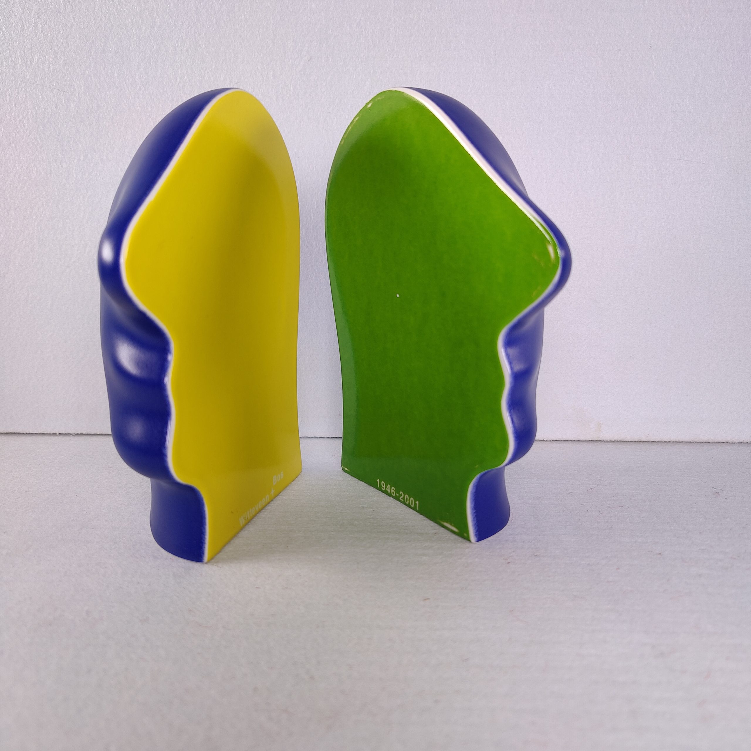 Binnenzijde van beide delen van "Split Personality", met een gele en een groene holle gezichtsvorm omkaderd door blauw.